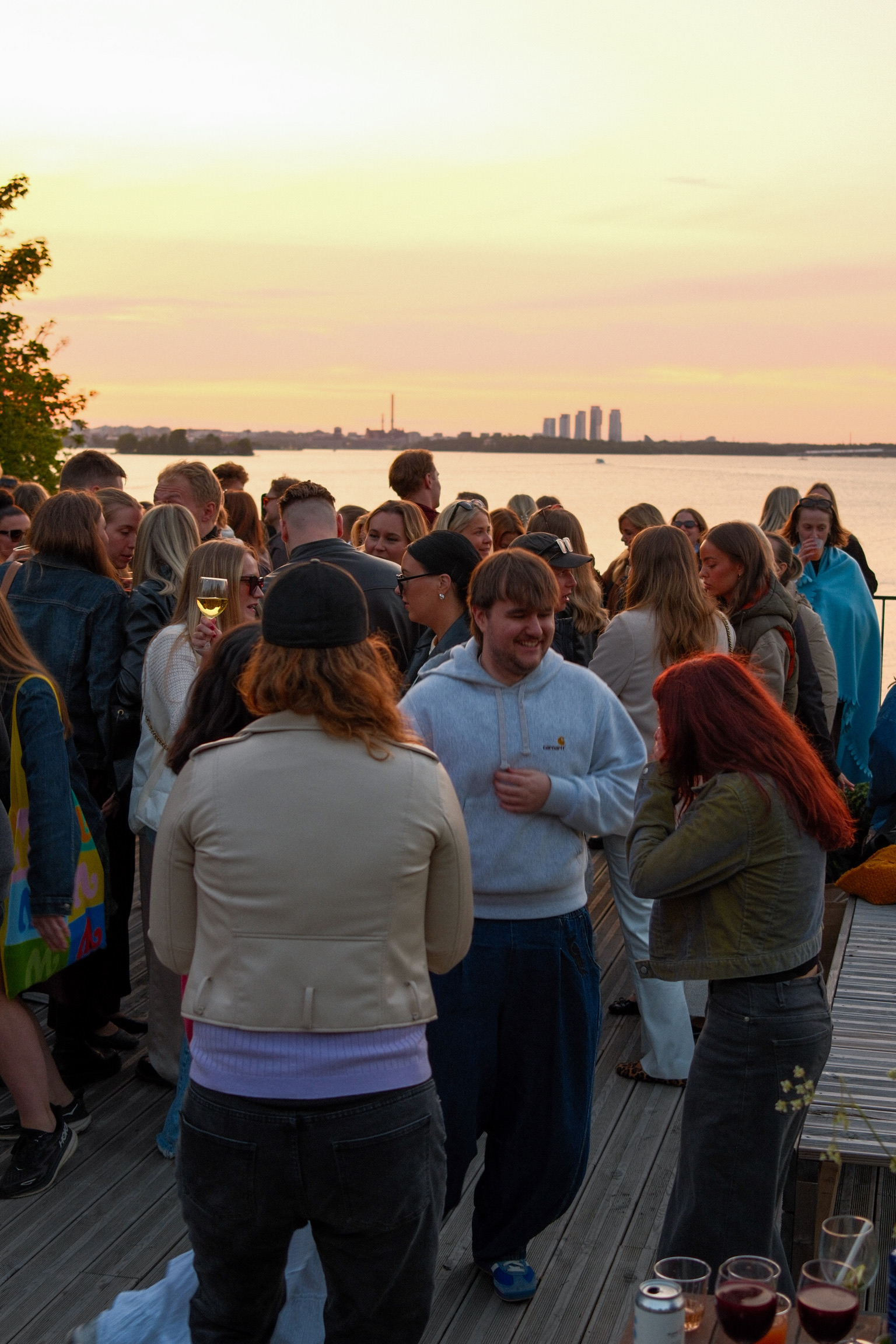 Auringonlasku Vallisaaren terassilta, viinilasit pöydällä